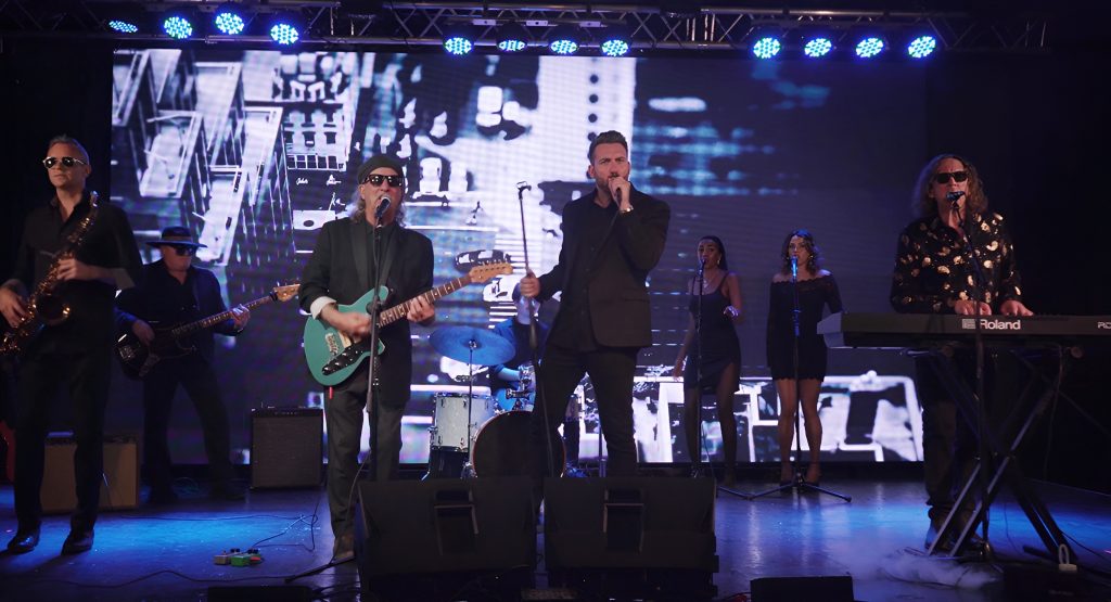 The Expanding Man band performing live on stage.